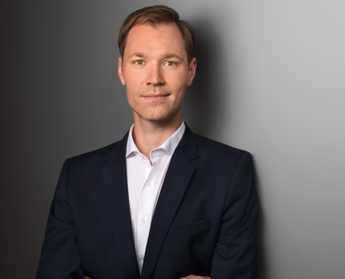 Das Profilbild von Julius van de Laar im Anzug vor grauem Hintergrund bei der Redneragentur PODIUM