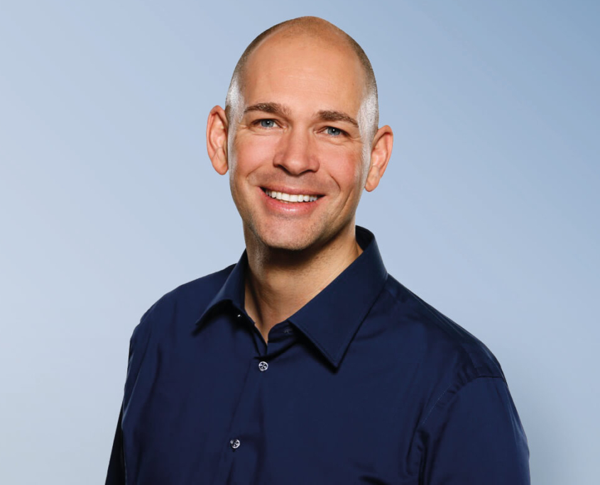 Das Profilbild von Marc Wallert vor blauem Hintergrund bei der Redneragentur PODIUM