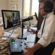 Leif Ahrens sitzt am Schreibtisch und moderiert und produziert einen Podcast