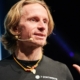 Norman Bücher bei einem Keynote-Vortrag auf der Bühne – Das Profilbild bei der Redneragentur PODIUM.