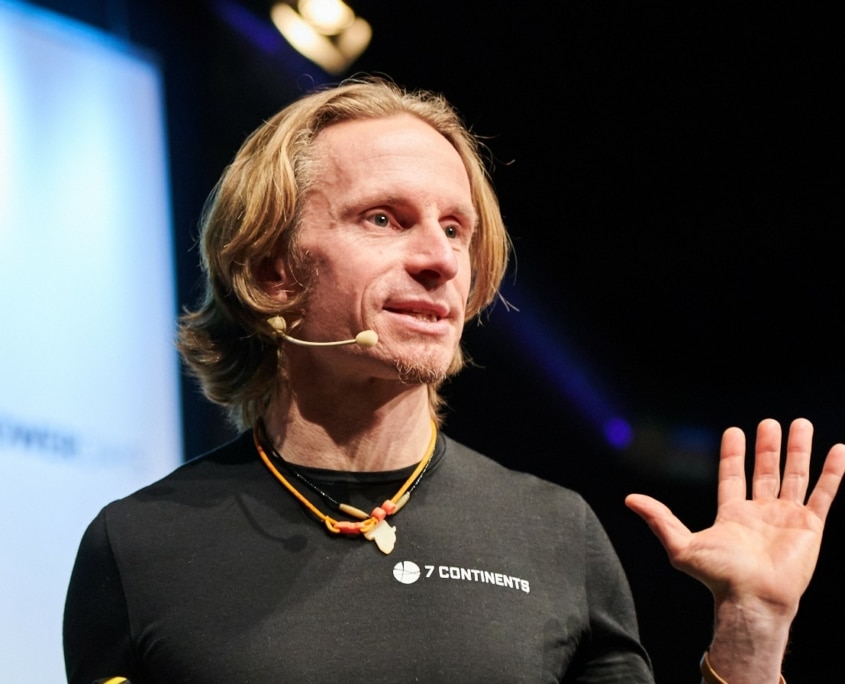 Norman Bücher bei einem Keynote-Vortrag auf der Bühne – Das Profilbild bei der Redneragentur PODIUM.