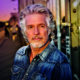 Das Profilbild von Frank Schätzing bei der Redneragentur PODIUM zeigt ihn vor einer urbanen Kulisse mit Graffiti und Sonnenuntergang – ein ausdrucksstarkes Porträt des bekannten Redners.