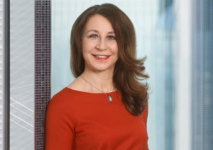Dr. Gertrud Traud im Profilbild bei der Redneragentur PODIUM, professionell posierend vor Glasfassade